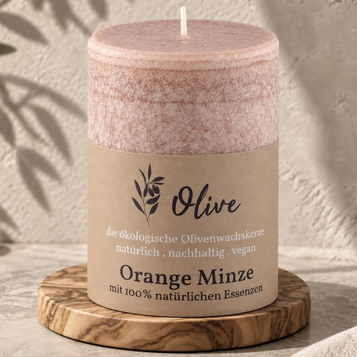 Schulthess Olivenwachskerze Orange & Minze auf einem runden Holzteller