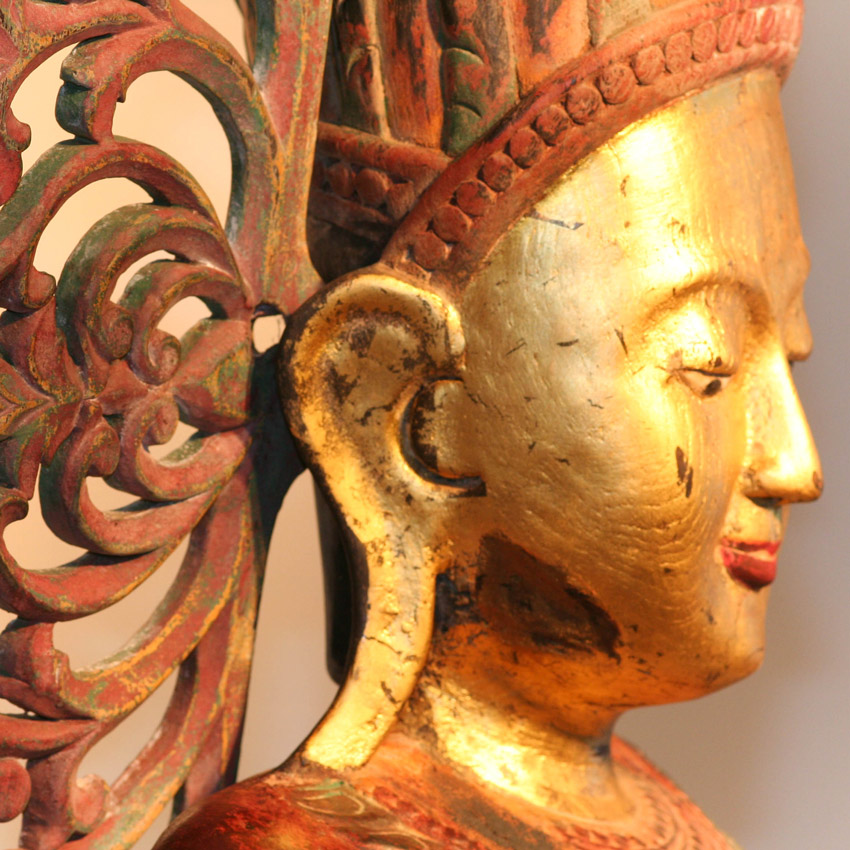 Detailansicht des großen burmesischen Königsbuddha, fein geschnitzte Krone und vergoldetes Gesicht mit roter Patina, traditionelles Kunsthandwerk.
